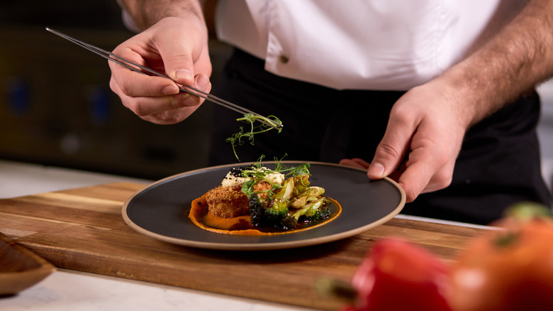 chef adding garnish to dish